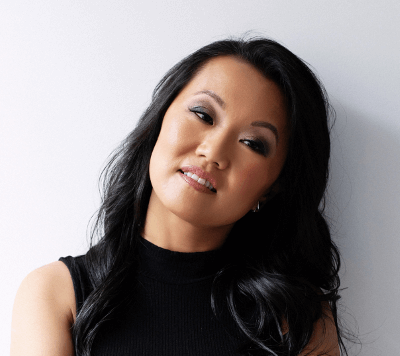 Headshot of Catherine Lewis, a Chinese Canadian woman with wavy black hair in a black dress.